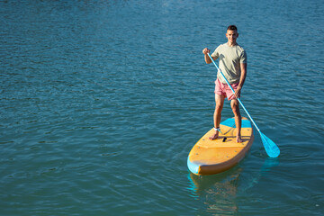 Man standing on the supboard in ocean.