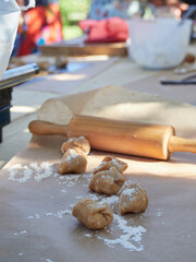 making homemade stuffed whole wheat pasta, ravioli. Outdoor on a table with a wooden rolling pin.