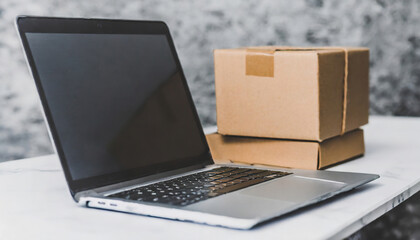 Laptop computer at workplace of start up small business owner cardboard parcel box of product for...