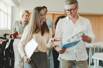 Portrait positive businesspeople wearing eyeglasses working with documents graphs in modern office