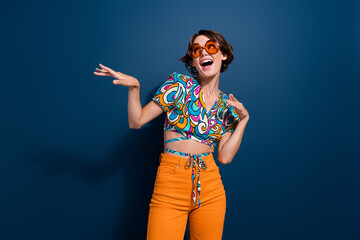 Photo of attractive woman dancing have fun look empty space wear trendy flared pants jeans clothes isolated on dark blue color background