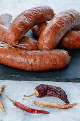 This is a photograph of Nduja sausage from a front vertical view, placed on a black slate after...