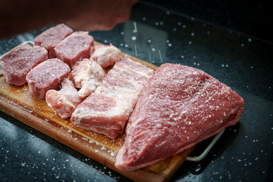 Temperando as carnes para churrasco com sal grosso. Colocando sal grosso com a m&atilde;o sobre os cortes para churrasco de picanha, costela, frango, ancho.