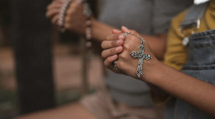 Mother and daughter putting their hands together to pray for God's blessings.