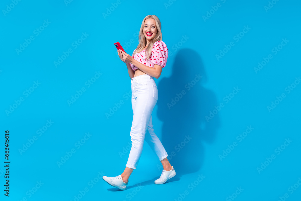 Poster full size photo of pretty young girl hold gadget walking wear trendy pink cherry print clothes isola