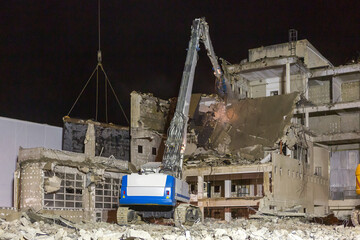Chantier de démolition d'un bâtiment en milieu urbain pendant la nuit. Création d'un espace libre pour un projet d'aménagement