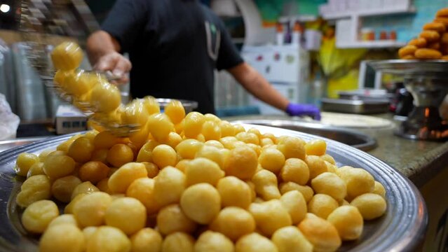 Close up of man cooking zalabia luqaimat balls. Freshly prepared sweets. Popular arabic street food