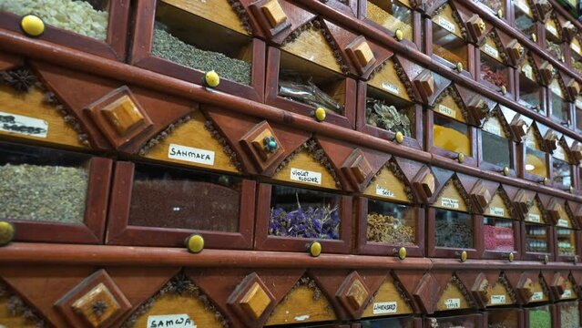 Vertical motion close up rows of boxes with egyptian herbs, tea and spices selling by weight in street shop