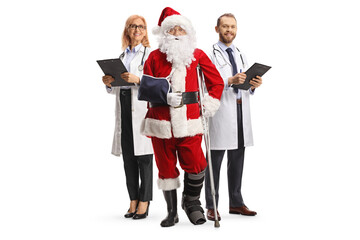 Injured santa claus with a foot brace and arm sling standing with a male and female doctors