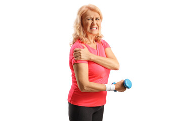Mature woman in sportswear with painful shoulder holding a dumbbell and looking at camera