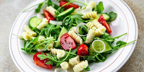 pasta salad fusilli pasta, cucumber, tomato, green lettuce, onion eating cooking meal food snack on the table copy space food background rustic top view