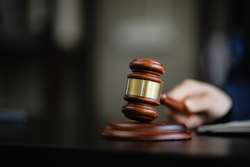 Hand holding a wooden gavel, a wooden legal gavel on an office desk, Judge gavel, Law,