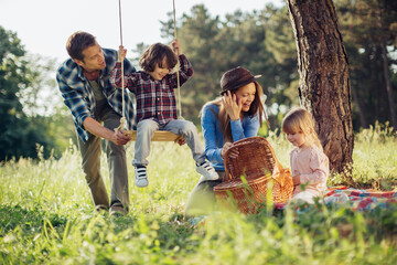 Happy young family having a picnic in the park during a sunny day