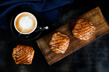 served on wooden board with cup of coffee latte art isolated on napkin top view of french breakfast...