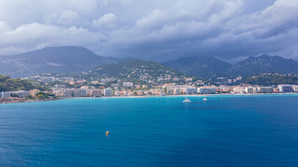 Fototapeta premium Aerial view of The French Riviera at Menton, France. Photography was shoot from a drone at a higher altitude from above the bay with the city and the mountains in the background on a stormy weather.