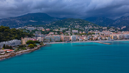 Fototapeta na wymiar Aerial view of The French Riviera at Menton, France. Photography was shoot from a drone at a higher altitude from above the bay with the city and the mountains in the background on a stormy weather.