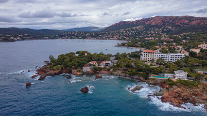 Fototapeta premium Aerial video of the Agay bay on the French Riviera. In the photography can be seen Agay lighthouse and a panorama of the bay, with mountains in the background. Photography was shot on a cloudy day.