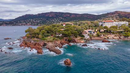 Fototapeta premium Aerial video of the Agay bay on the French Riviera. In the photography can be seen Agay lighthouse and a panorama of the bay, with mountains in the background. Photography was shot on a cloudy day.
