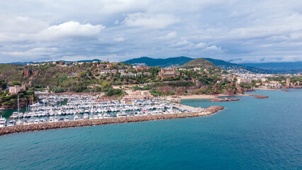Fototapeta premium Aerial view of Mount Turnei, located on the French Riviera. Photography was shot from a drone at a higher altitude from above the water wit the beautiful marina and beach in the view.
