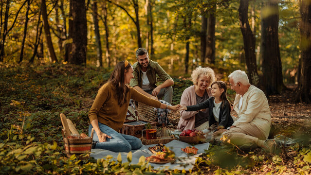 Whole happy Caucasian family having a picnic in the forest
