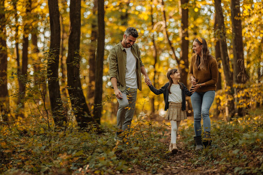 Mother, father and their daughter having a walk trough the forest