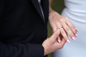 During the wedding ceremony, the groom puts a wedding ring on the bride's finger. Wedding traditions.