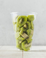 Slices of kiwi in a clear glass. Fruit salad, takeaway food.