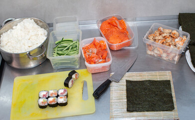 Preparing sushi. Nori and other ingredients are laid out on the table of a Japanese restaurant for the process of preparing sushi rolls.