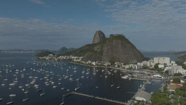 Aerial view of the Sugarloaf mountain (Pao de Acucar) in Botafogo district with sailing boat docket along the bay on the beach, Rio de Janeiro, Brazil.