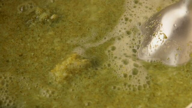 Blender grinds broccoli in a pot of hot water