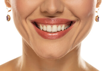 Close-up of a woman's mouth, capturing a confident smile and perfect natural teeth and lips.