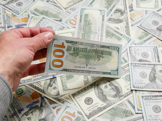 Man holding сто dollar notes, close up on hand.