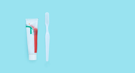 Dental care ad. Dental hygiene and treatment. Closeup of a toothbrush and toothpaste on blurred blue background. Means to care for the oral cavity.
