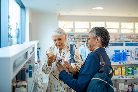 Diverse pair of senior female friends browsing the shelfs of a drugstore