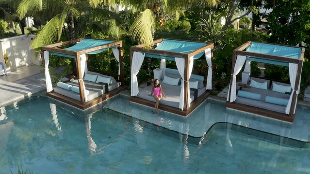Aerial view of a woman relaxing along the swimming pool in a luxury resort, Poste de Flacq, Flacq district, Mauritius.