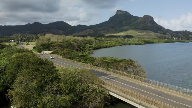 Mauritius - 21 September 2023: Aerial view of a beautiful car driving across a bridge along the coast.