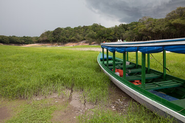 Boat stranded on dry river in extreme drought in the Amazon Rainforest, the largest tropical forest...
