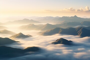 Aerial view of mountain ridges veiled in mist during golden hour