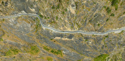 aerial view of a road on the edge of mountains carved out of rocks
