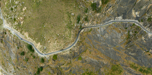 aerial view of a road on the edge of mountains carved out of rocks
