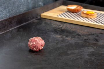 manufacturing and cooking process of homemade meat burgers on an iron plate with chedar cheese and pan bread and wrapping