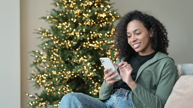 Young woman using smartphone at home during Christmas holiday, Student girl texting on mobile phone indoors, Connection, online shopping, winter lifestyle concept