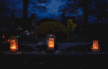 Votive candles lantern burning on the graves in Slovak cemetery at night time. All Saints' Day. Solemnity of All Saints. Hallows eve. 1st November. Feast of Saints. Hallowmas. Souls' Day in Slovakia