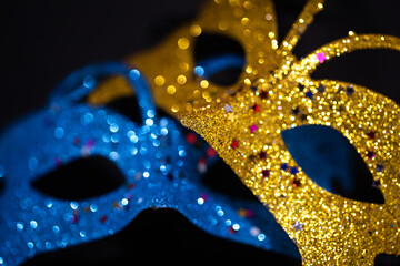 Luxurious Venetian shiny masks on a dark background. Carnival masquerade fantasy mask. Holiday and party concept. Blurred photo. - obrazy, fototapety, plakaty