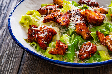 Vegetarian style caesar salad on wooden background.