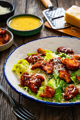 Vegetarian style caesar salad on wooden background.