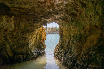 view through holes or caves in the rocks of Kalipi beach with clear waters in the Republic of Cyprus.