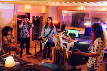 Creative band on a recording session in a music studio.