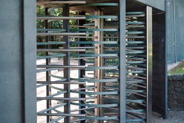 Controlled access revolving door with metal security bars.