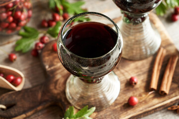 Medicinal wine prepared from fresh hawthorn berries in a cup made of so called forest glass full of air bubbles